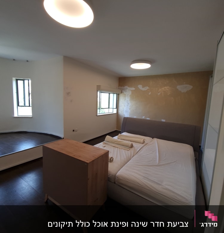 קיר צבוע חלקית עם כתמי צבע לבנים